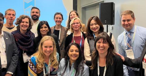 A group of people smiles at the camera.