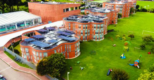 A curved school building against a natural setting.