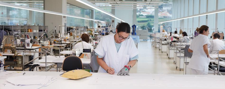 A woman at a lab table in a large facility.
